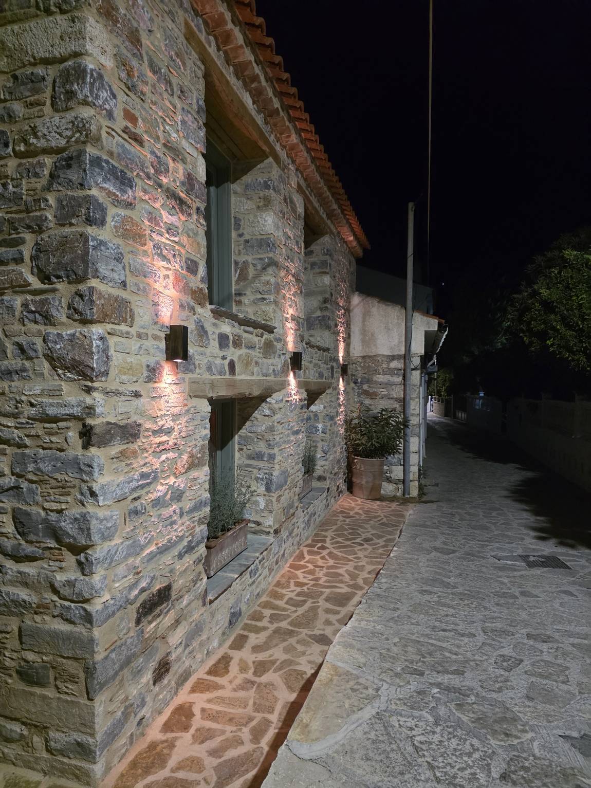 Wandlampen die het metselwerk koperkleurig aanstralen